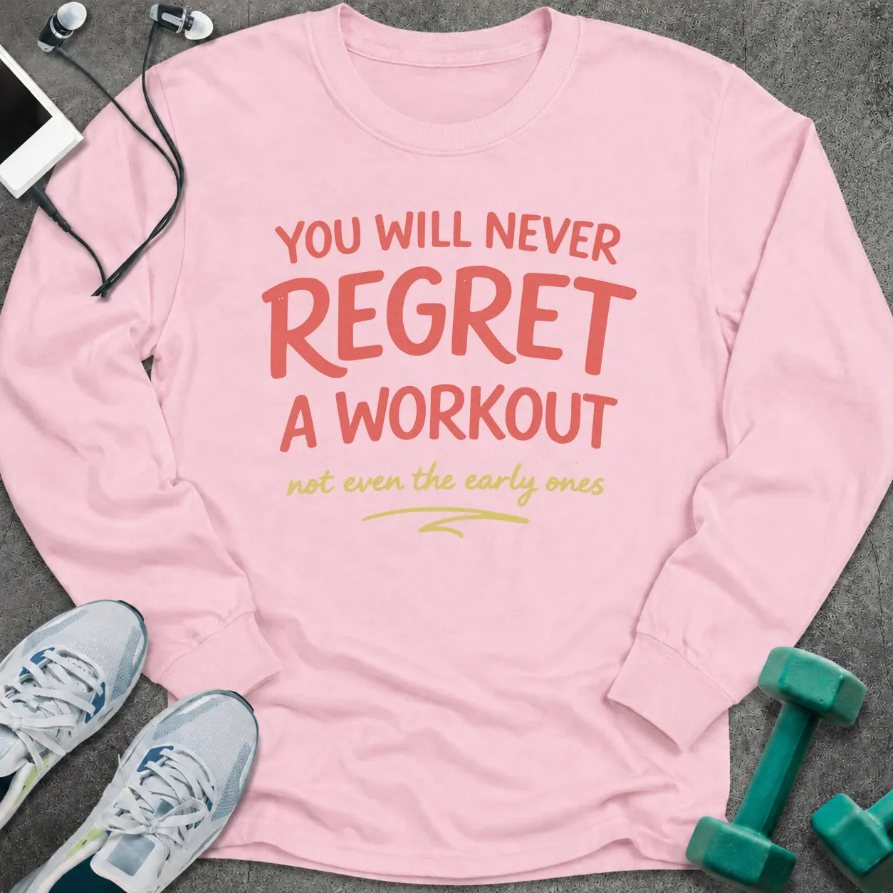 Light pink long sleeve tee printed with "You Will Never Regret A Workout, not even the early ones" in coral and gold