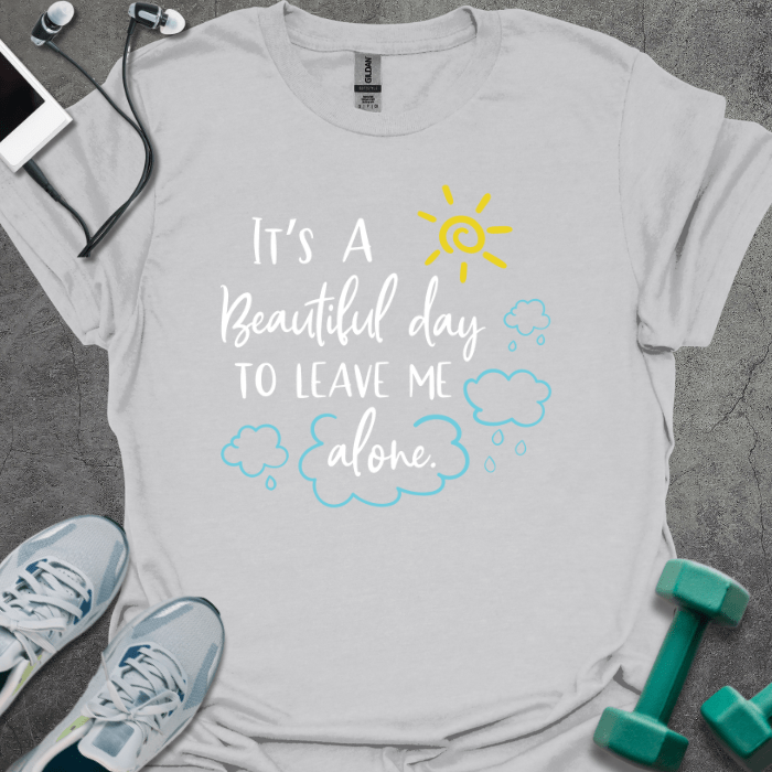 Ice grey t-shirt printed with "IT'S A Beautiful day TO LEAVE ME alone" in yellow and blue, with sun and clouds and rain