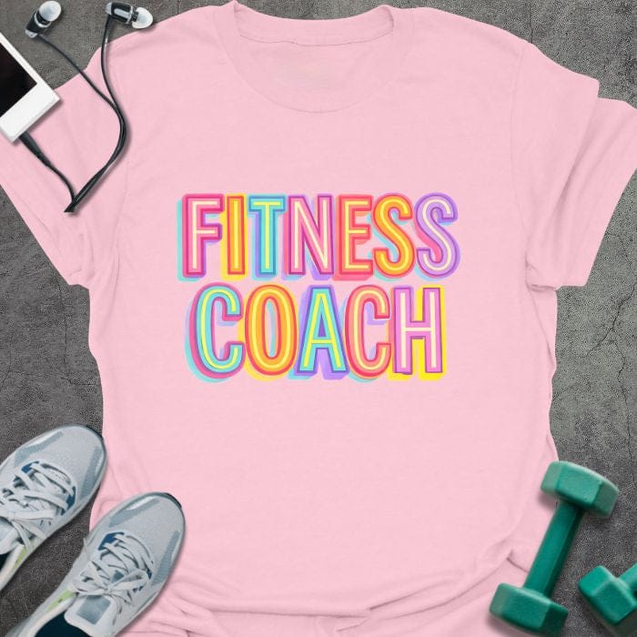 Light pink t-shirt printed with "Fitness Coach" in multi-color