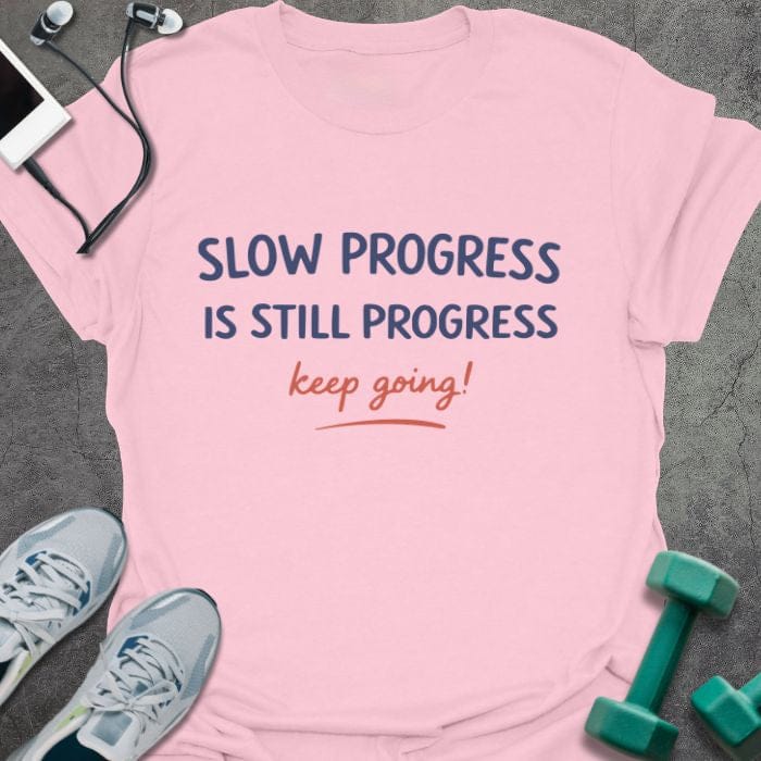 Light pink t-shirt printed with "SLOW PROGRESS IS STILL PROGRESS keep going!" in red