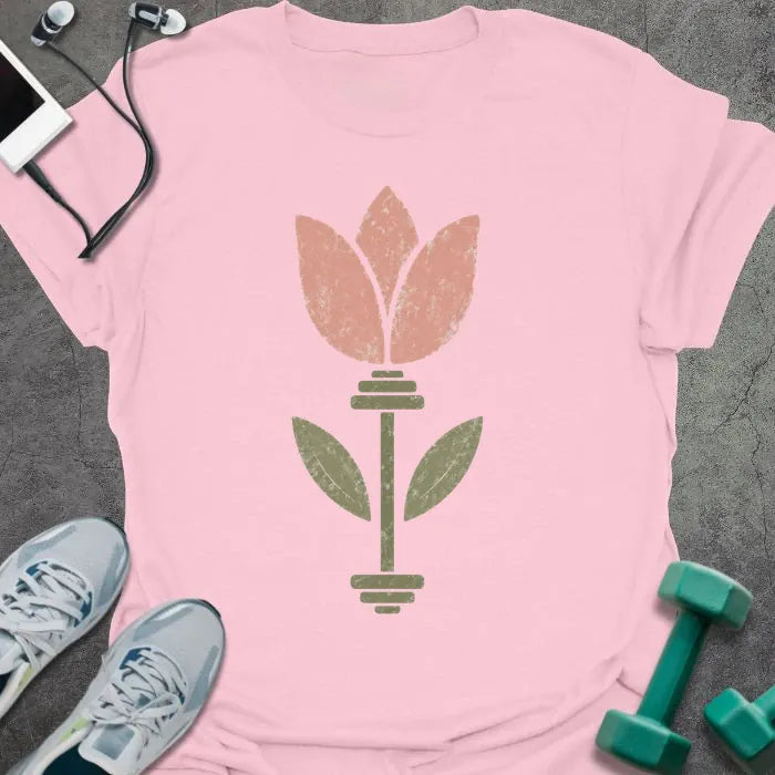 Light pink t-shirt with an illustration of tulip flowers surrounding a barbell in coral and green