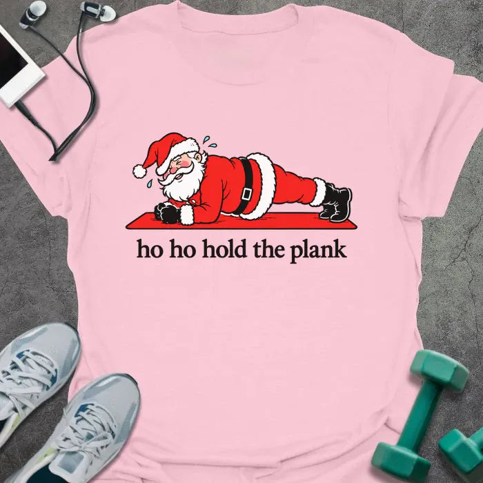 Light pink t-shirt printed with "ho ho hold the plank" in black, with Santa holding a plank on a red mat