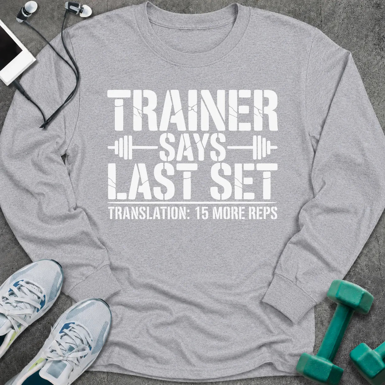 Sport grey long sleeve tee printed with "Trainer Says Last Set. Translation: 15 More Reps" in white, with barbell accents