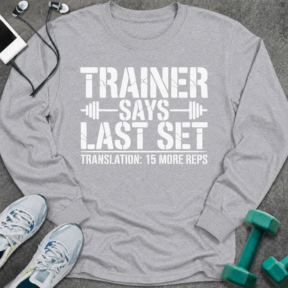 Sport grey long sleeve tee printed with "Trainer Says Last Set. Translation: 15 More Reps" in white, with barbell accents