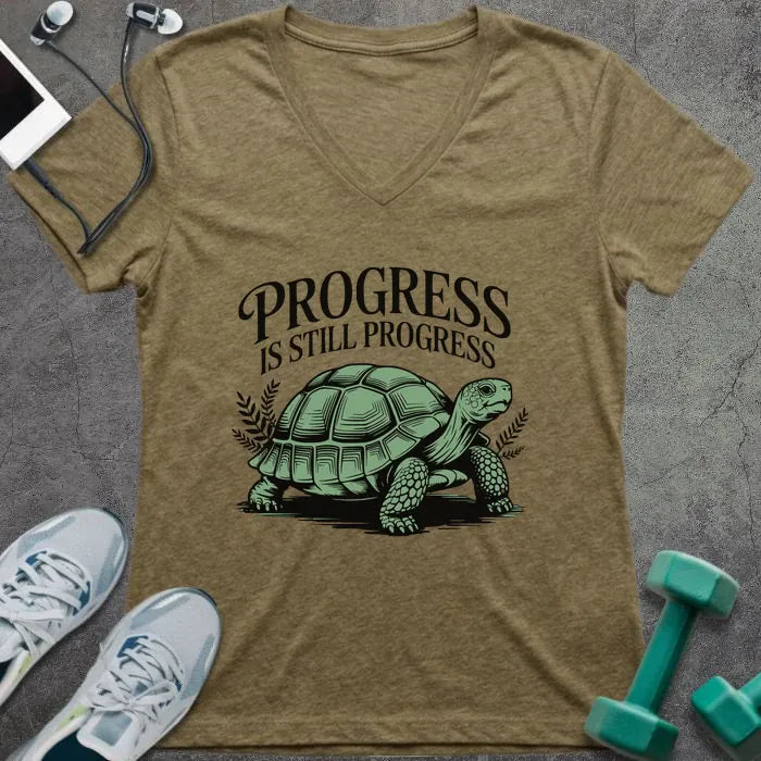 Tan v-neck showing turtle with "PROGRESS IS STILL PROGRESS" text
