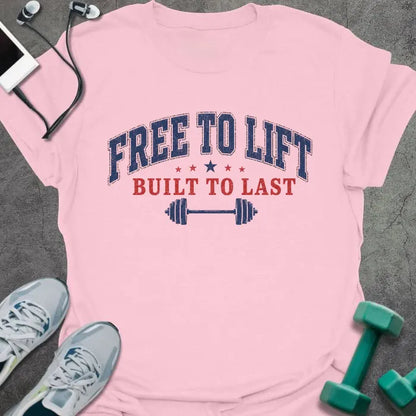 Pink t-shirt with "FREE TO LIFT, BUILT TO LAST" text and patriotic barbell design