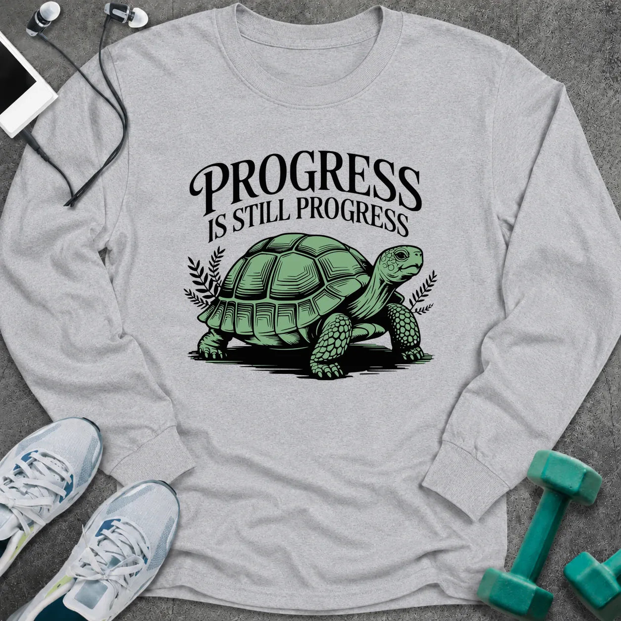 Ash long sleeve tee printed with "Progress Is Still Progress" in black, with a tortoise