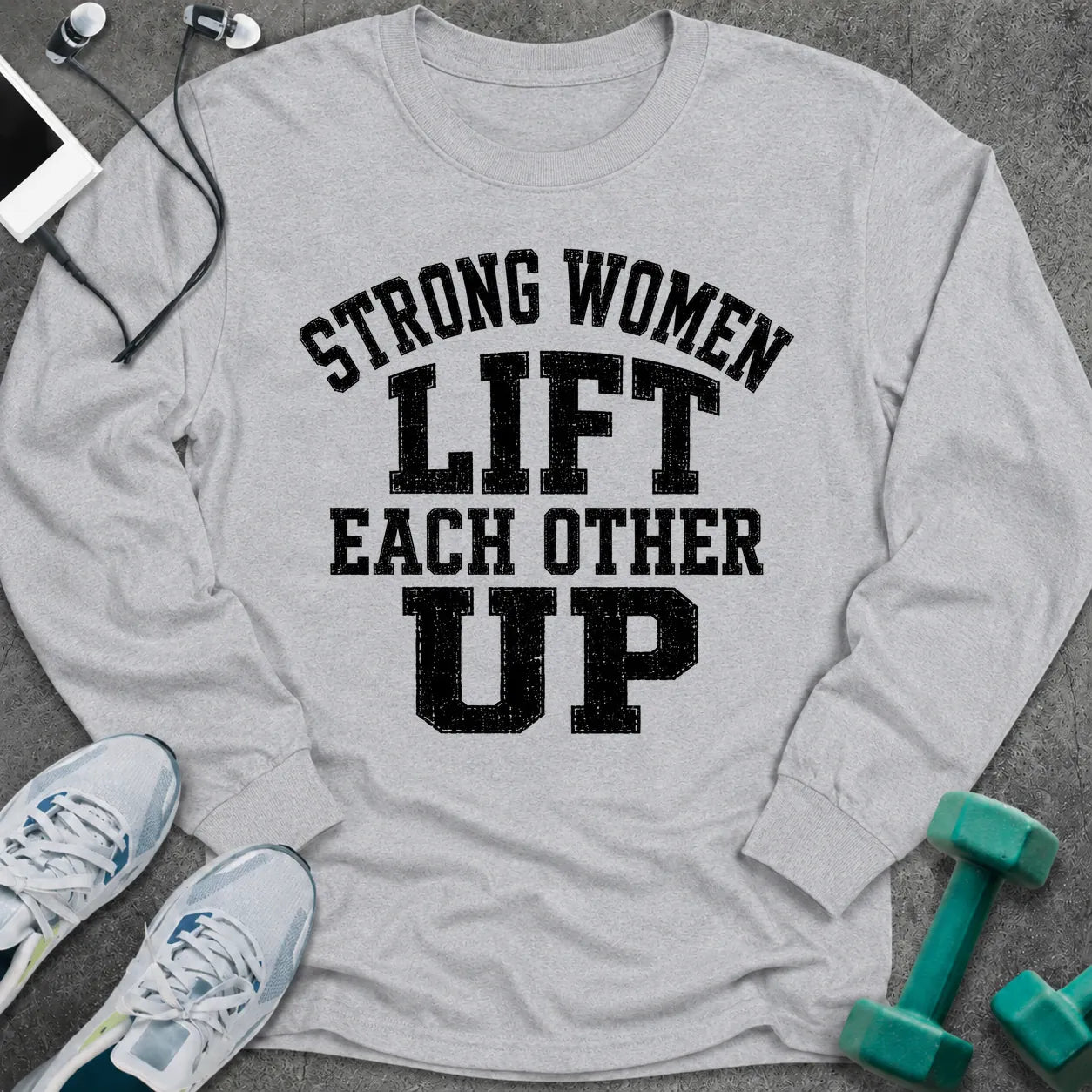 Ash long sleeve tee printed with "Strong Women Lift Each Other Up" in black distressed varsity lettering