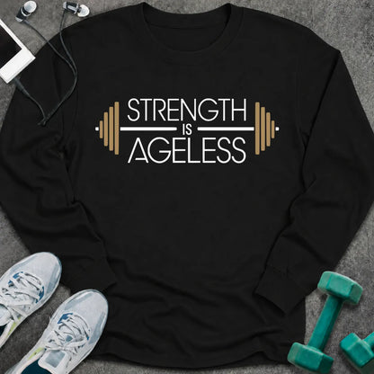 Black long sleeve tee printed with "Strength is Ageless" in white and gold, with a barbell framing the words