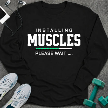 Black long sleeve tee printed with "Installing Muscles Please Wait" in white, with a green loading bar
