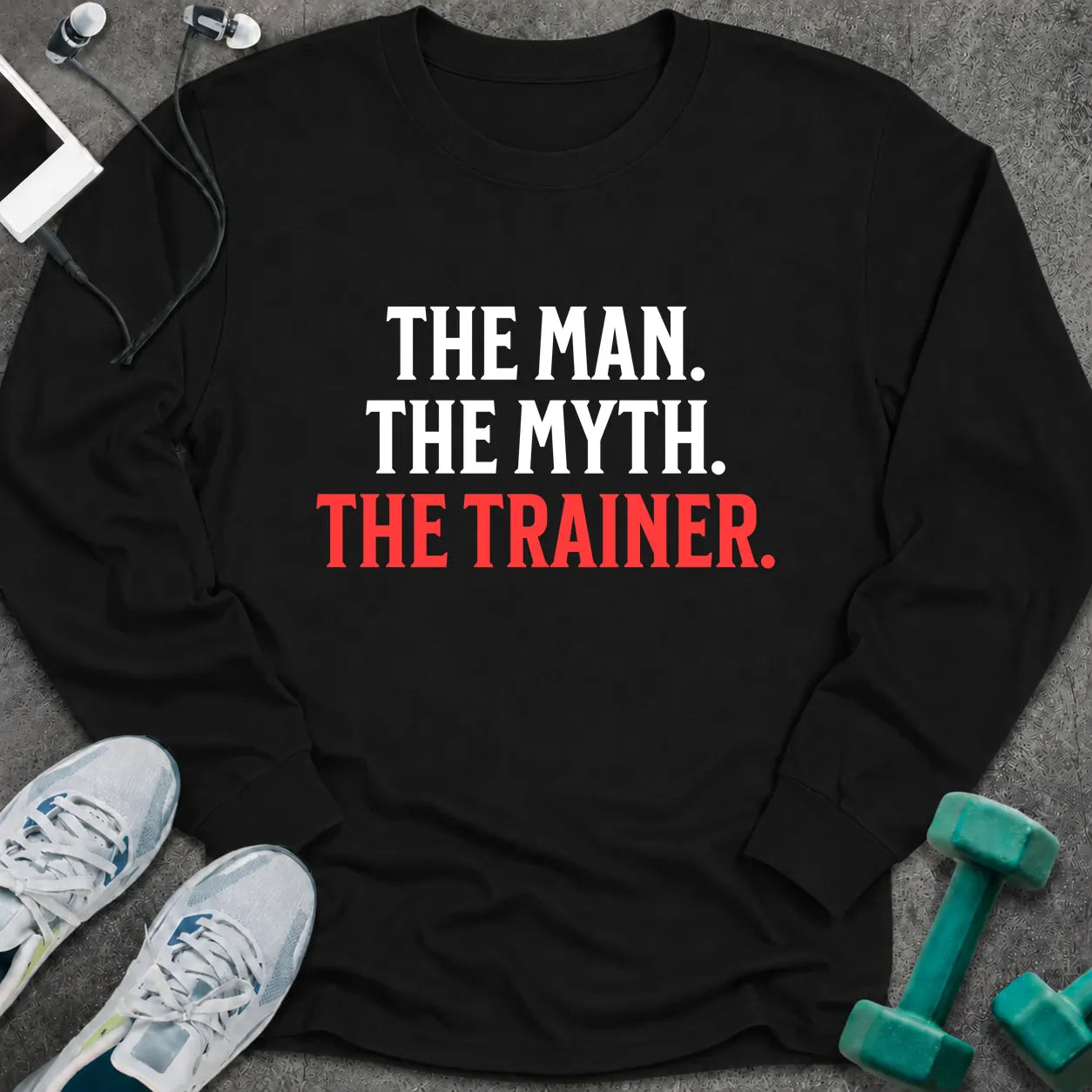 Black long sleeve tee printed with "The Man. The Myth. The Trainer." in white and coral
