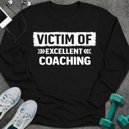 Black long sleeve tee printed with "Victim Of Excellent Coaching" in white, with a painted brush stroke banner