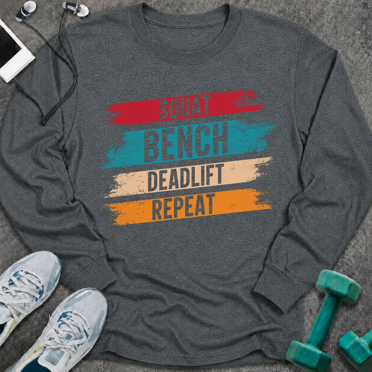 Dark heather long sleeve tee printed with "Squat Bench Deadlift Repeat" in white, with teal, cream and orange brush strokes behind each word