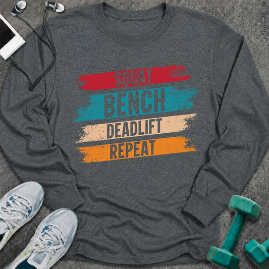 Dark heather long sleeve tee printed with "Squat Bench Deadlift Repeat" in white, with teal, cream and orange brush strokes behind each word