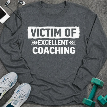 Dark heather long sleeve tee printed with "Victim Of Excellent Coaching" in white, with a painted brush stroke banner