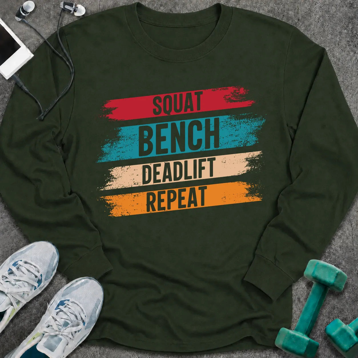 Forest green long sleeve tee printed with "Squat Bench Deadlift Repeat" in white, with teal, cream and orange brush strokes behind each word