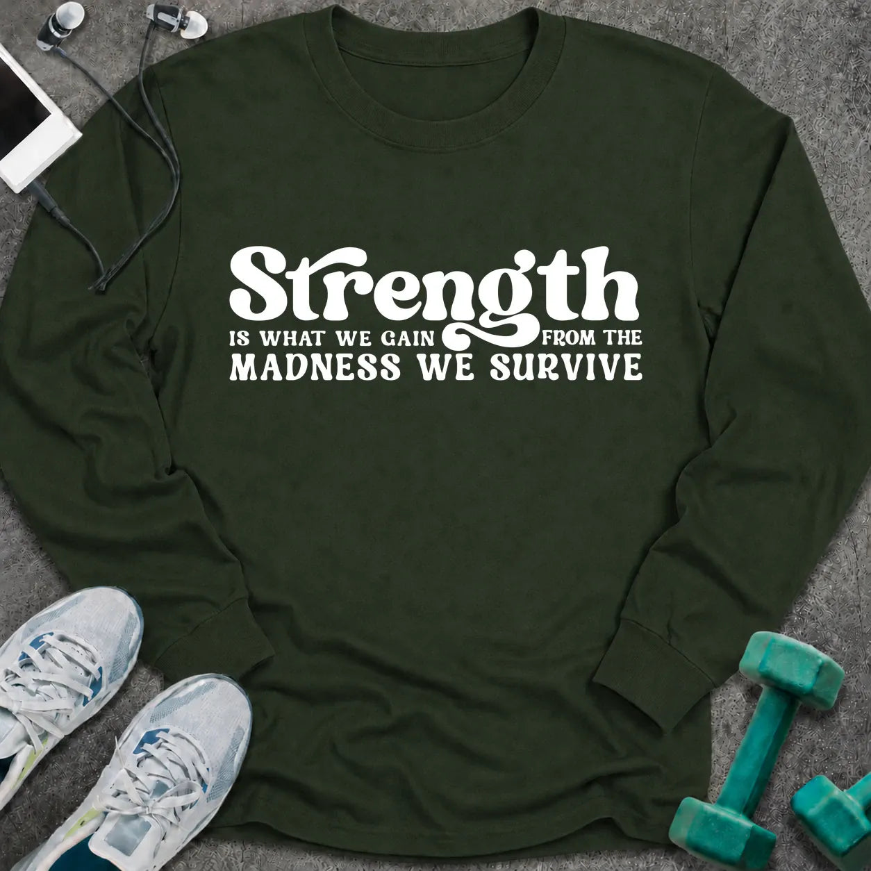 Forest green long sleeve tee printed with "Strength Is What We Gain From The Madness We Survive" in white