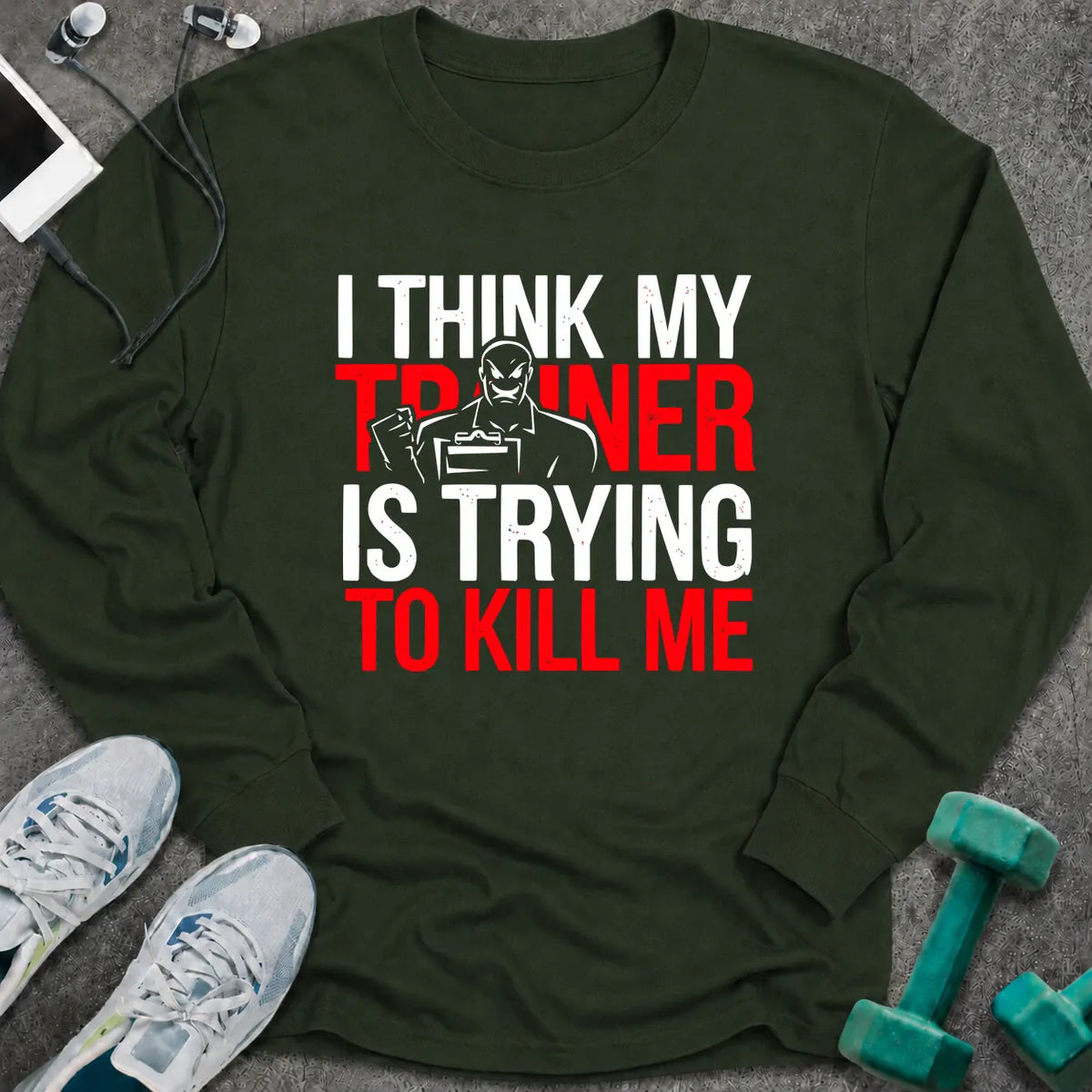 Forest green long sleeve tee printed with "I Think My Trainer Is Trying To Kill Me" in white and red, with a trainer figure behind the lettering