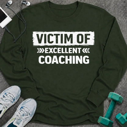 Forest green long sleeve tee printed with "Victim Of Excellent Coaching" in white, with a painted brush stroke banner