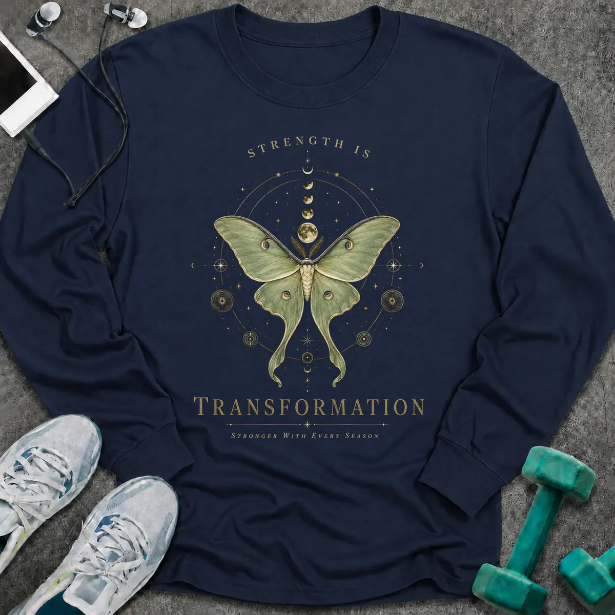 Navy long sleeve tee printed with "Strength Is Transformation" in gold, with a luna moth beneath a row of moon phases