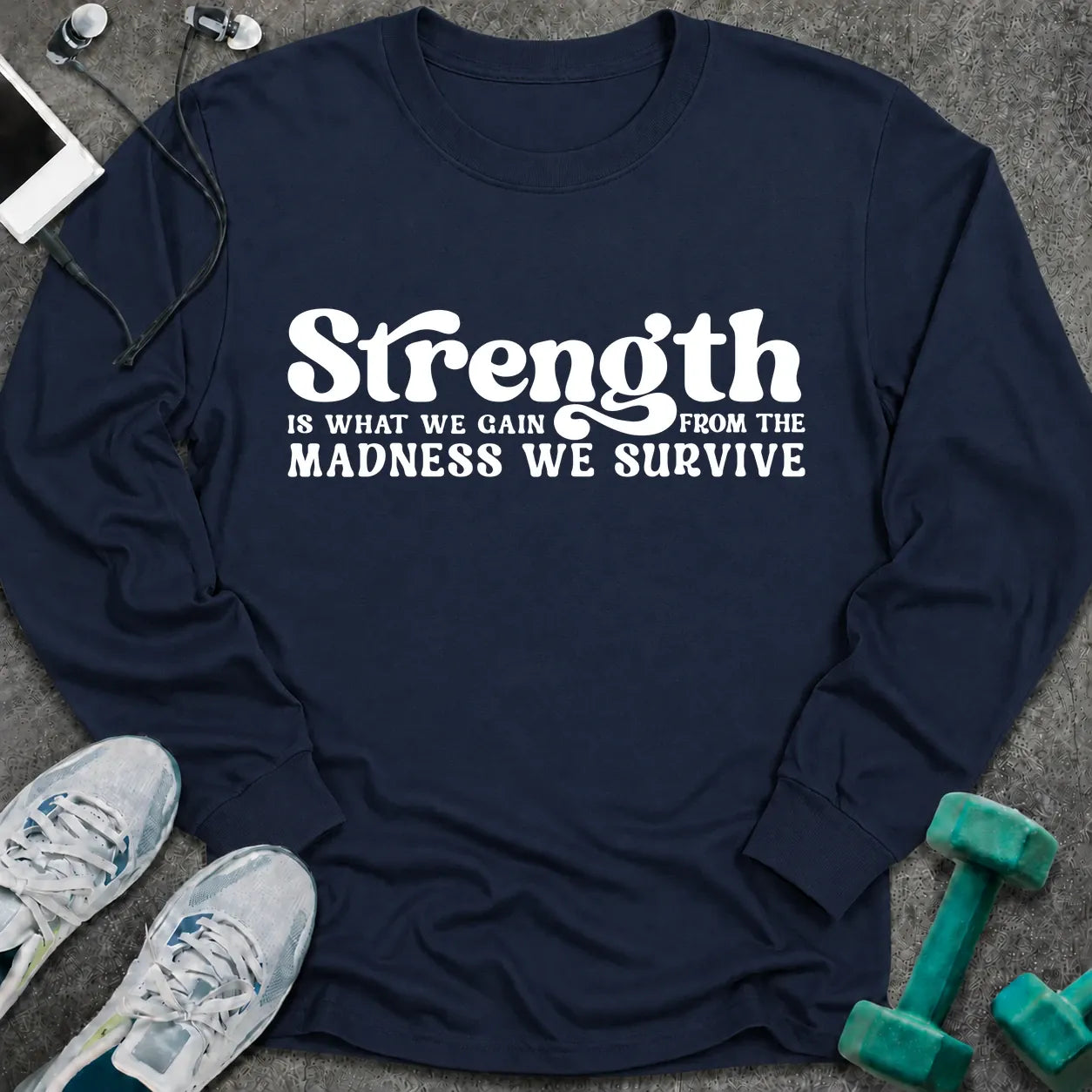 Navy long sleeve tee printed with "Strength Is What We Gain From The Madness We Survive" in white