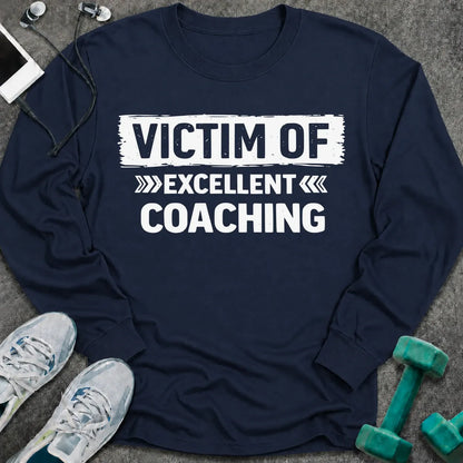 Navy long sleeve tee printed with "Victim Of Excellent Coaching" in white, with a painted brush stroke banner