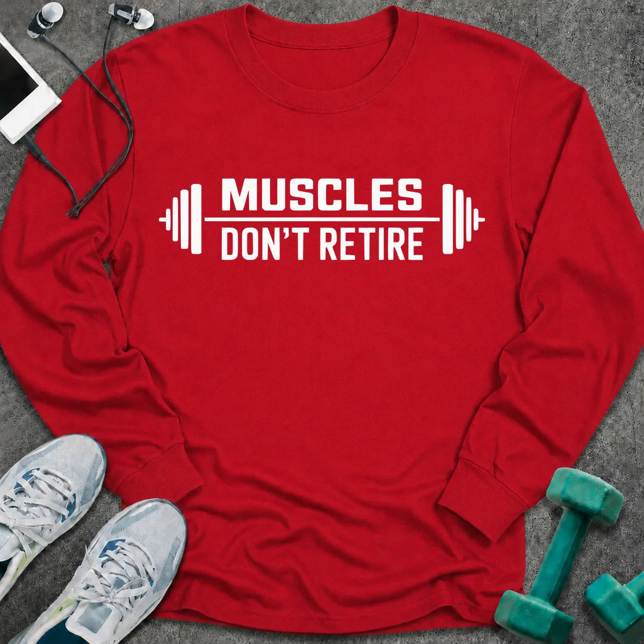 Red long sleeve tee printed with "Muscles Don't Retire" in white, with barbells on either side