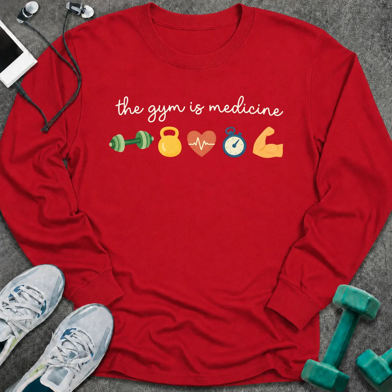 Red long sleeve tee printed with "the gym is medicine" in white script, with dumbbell, kettlebell, heart, stopwatch and flexed arm icons