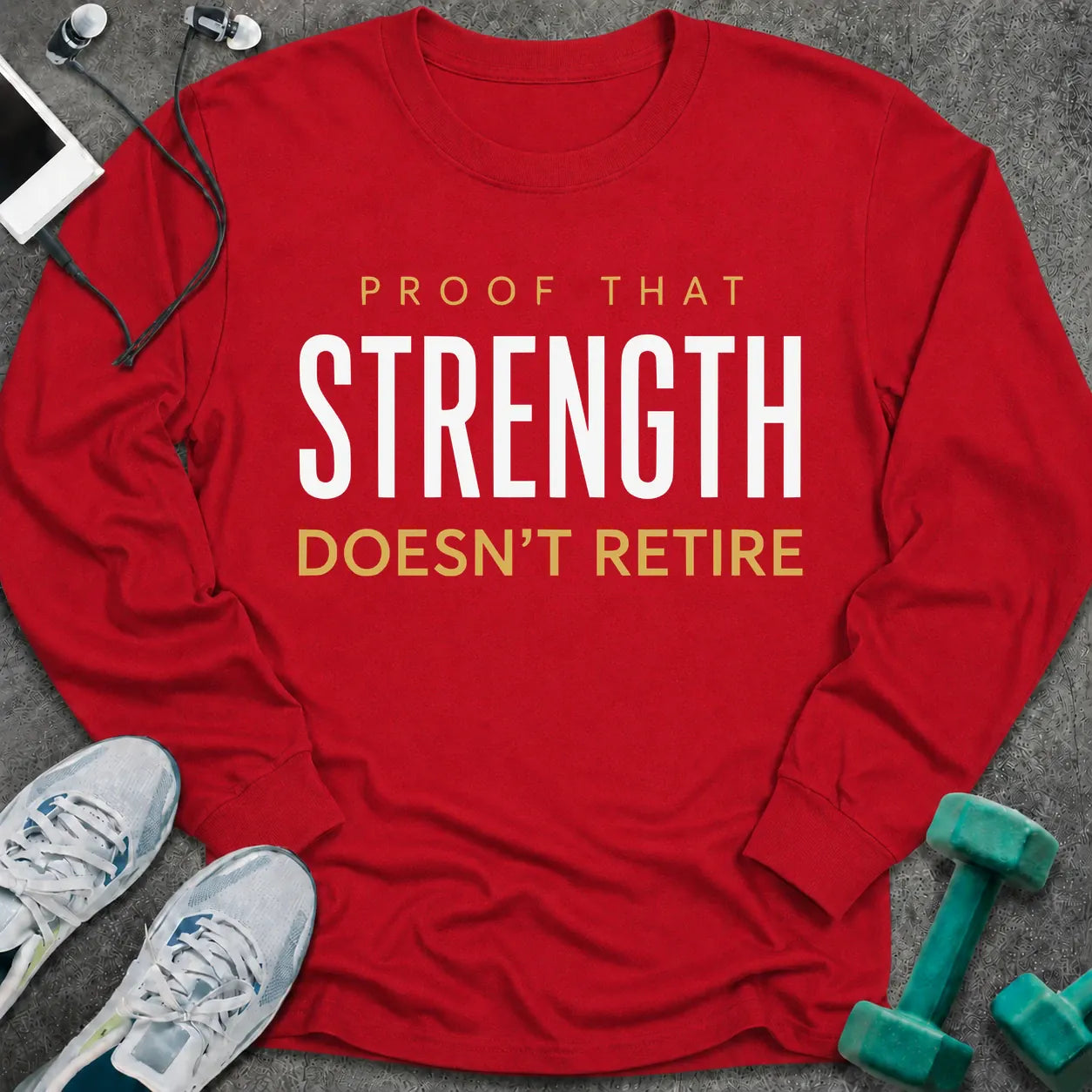 Red long sleeve tee printed with "Proof That Strength Doesn't Retire" in white and gold