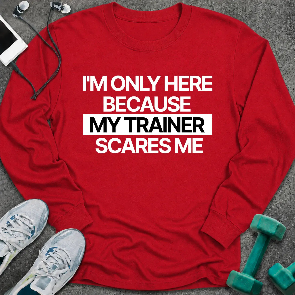 Red long sleeve tee printed with "I'm Only Here Because My Trainer Scares Me" in white with a black highlight bar