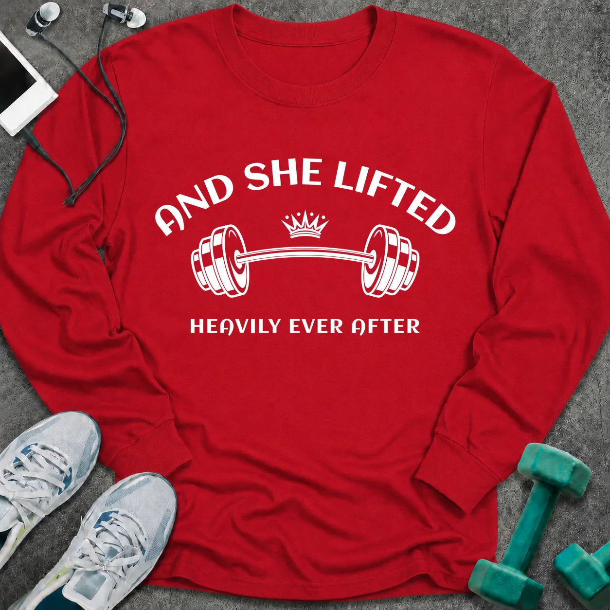 Red long sleeve tee printed with "And She Lifted Heavily Ever After" in white, with a barbell topped with a crown