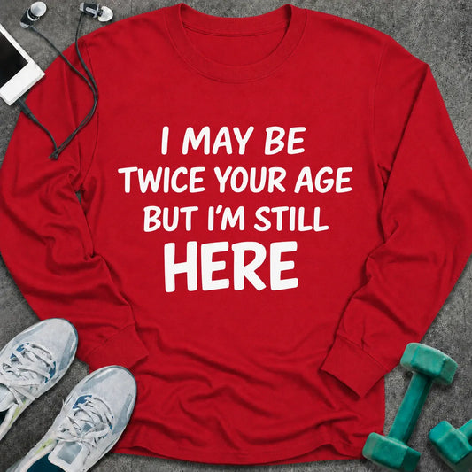 Red long sleeve tee printed with "I May Be Twice Your Age But I'm Still Here" in white