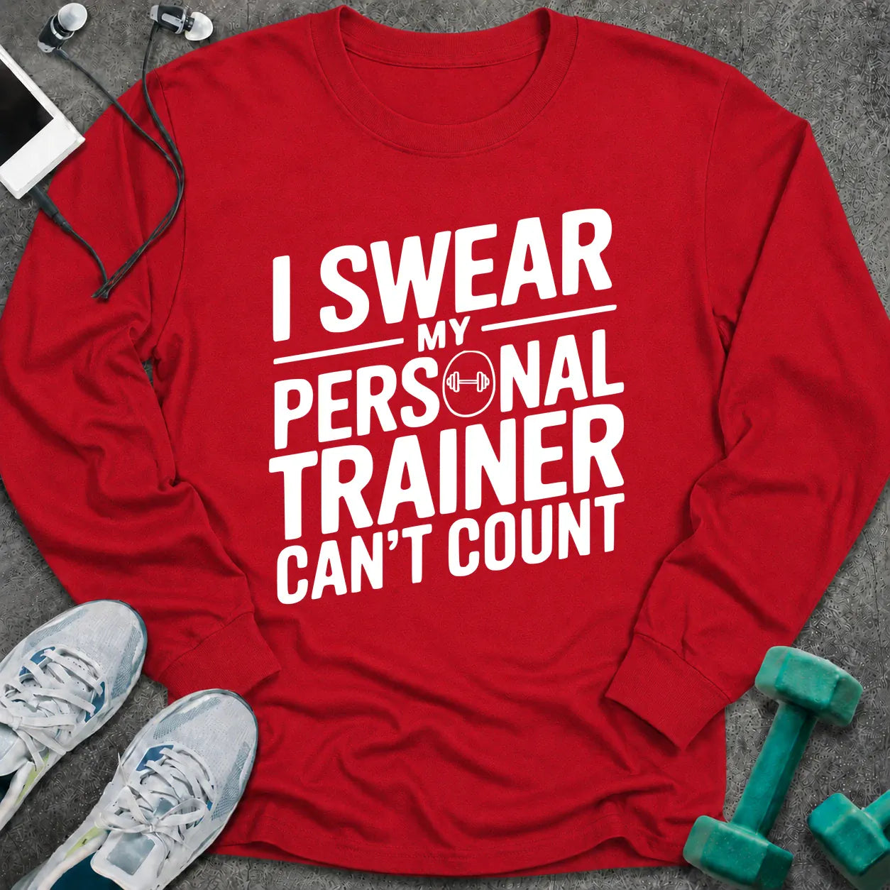 Red long sleeve tee printed with "I Swear My Personal Trainer Can't Count" in white, with a dumbbell set into the lettering