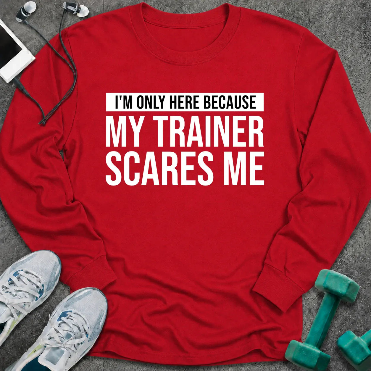 Red long sleeve tee printed with "I'm Only Here Because My Trainer Scares Me" in white with a black highlight bar