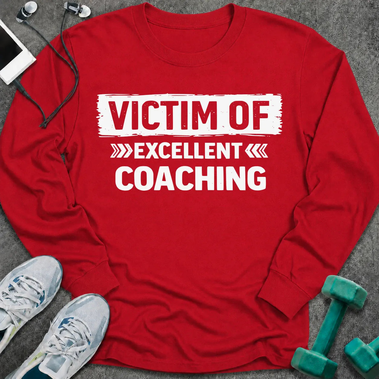 Red long sleeve tee printed with "Victim Of Excellent Coaching" in white, with a painted brush stroke banner
