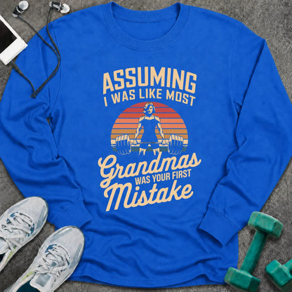 Royal long sleeve tee printed with "Assuming I Was Like Most Grandmas Was Your First Mistake" in cream and gold, with a woman deadlifting inside a retro sunburst