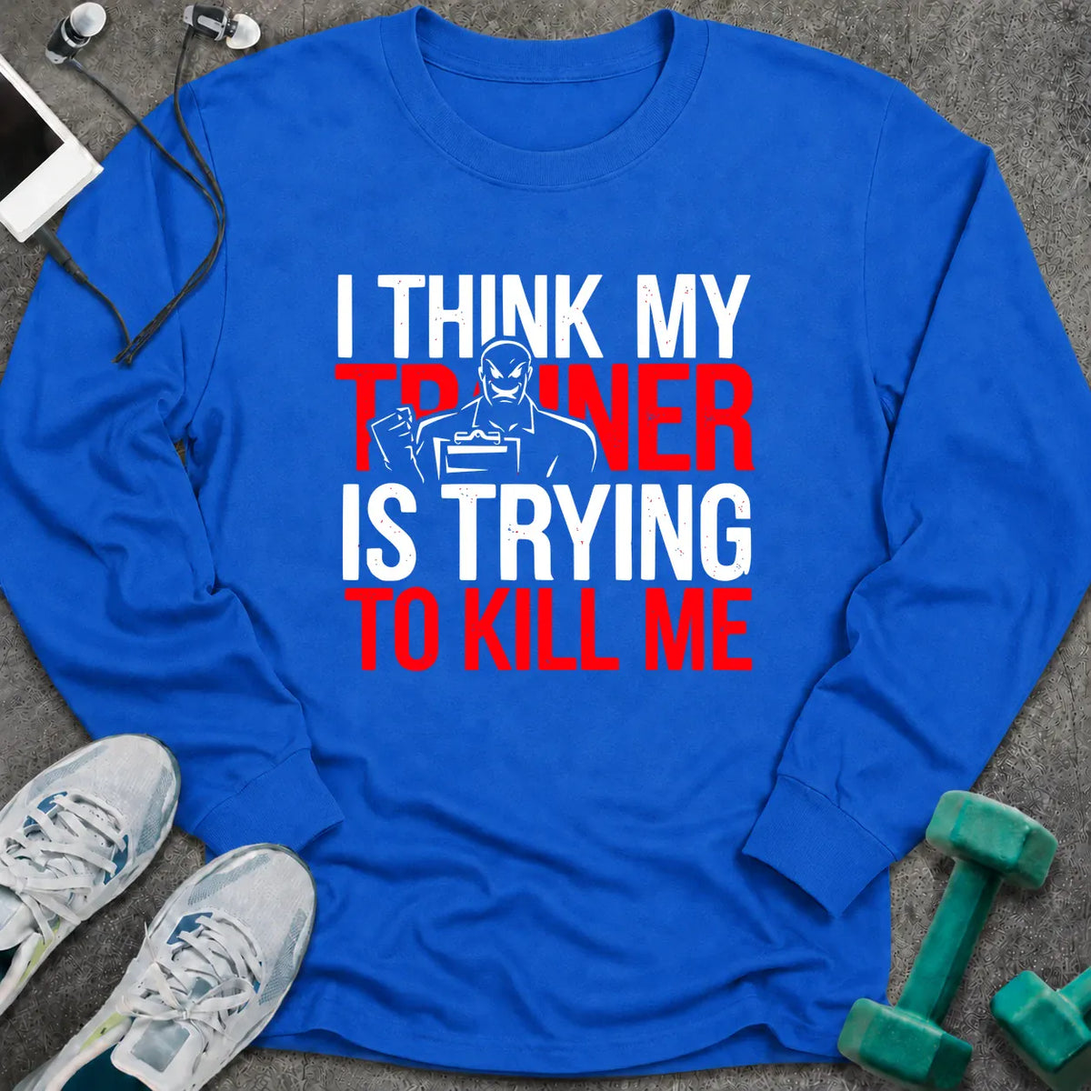 Royal long sleeve tee printed with "I Think My Trainer Is Trying To Kill Me" in white and red, with a trainer figure behind the lettering