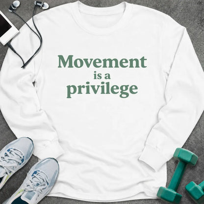 White long sleeve tee printed with "Movement is a privilege" in green serif lettering
