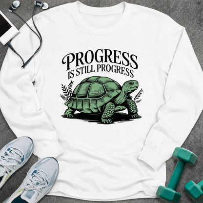 White long sleeve tee printed with "Progress Is Still Progress" in black, with a tortoise