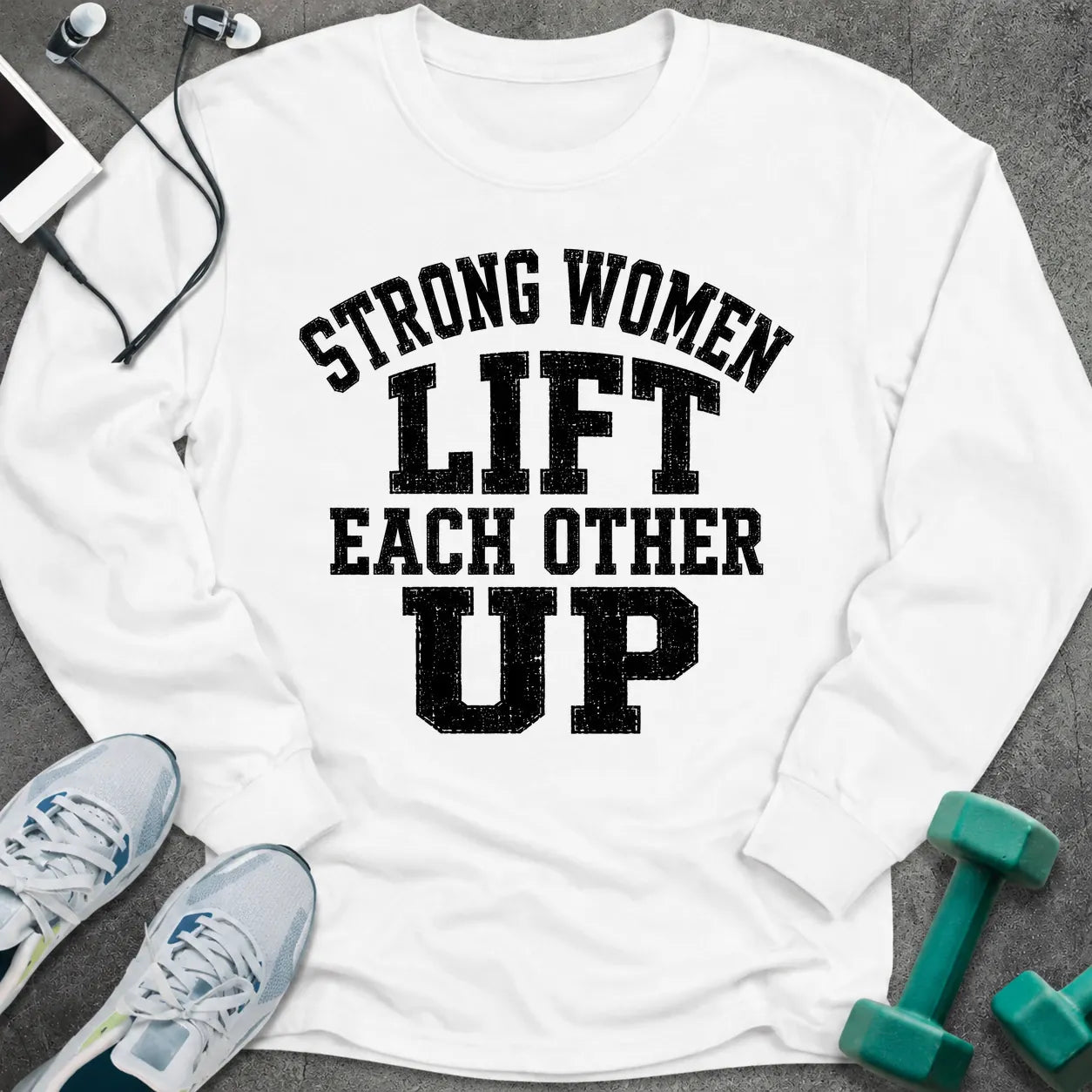 White long sleeve tee printed with "Strong Women Lift Each Other Up" in black distressed varsity lettering