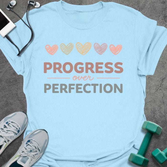 Light blue t-shirt with colored hearts and "PROGRESS over PERFECTION" text