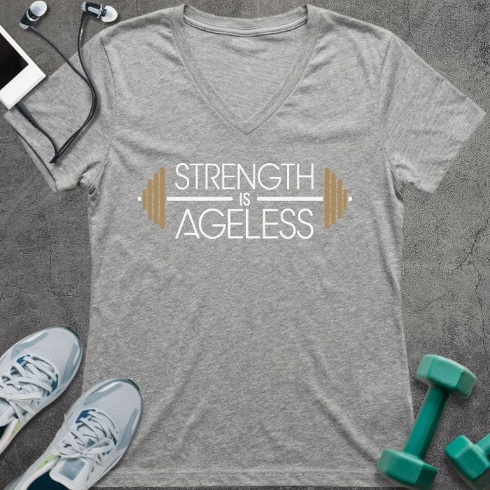 T-shirt printed with "Strength is Ageless" in white and gold, with barbell design elements