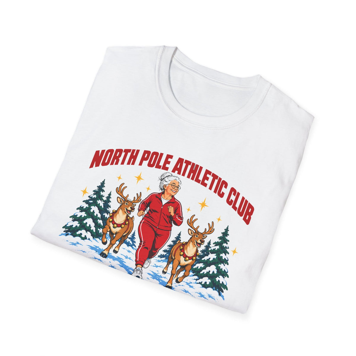 Folded white t-shirt printed with "NORTH POLE ATHLETIC CLUB" in red and "Winter Training Season" in green script, with a white-haired woman in a red tracksuit jogging between two reindeer through snowy pine trees