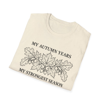 Folded natural t-shirt printed with "MY AUTUMN YEARS, MY STRONGEST SEASON" in black, with oak leaves and acorns