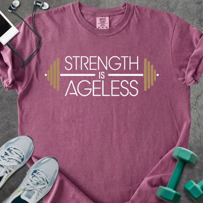 Berry t-shirt printed with "Strength is Ageless" in white and gold, with a barbell graphic
