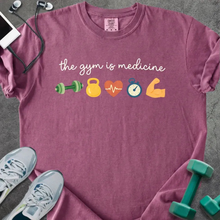 Berry t-shirt printed with "the gym is medicine 💪 🏋️ 💓 ⏰ 💪" in white and multicolor