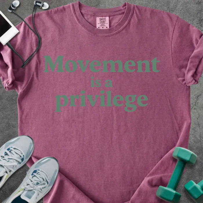 Berry t-shirt printed with "Movement is a privilege" in teal