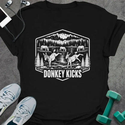 Black t-shirt printed with "DONKEY KICKS" in white, with two donkeys kicking up their back legs by a mountain lake and pine trees