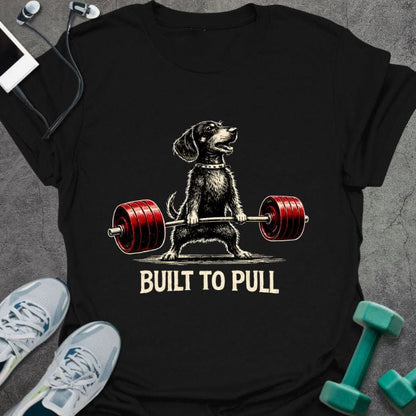 Black t-shirt printed with "Built to Pull" in white, red, with a dog lifting a barbell