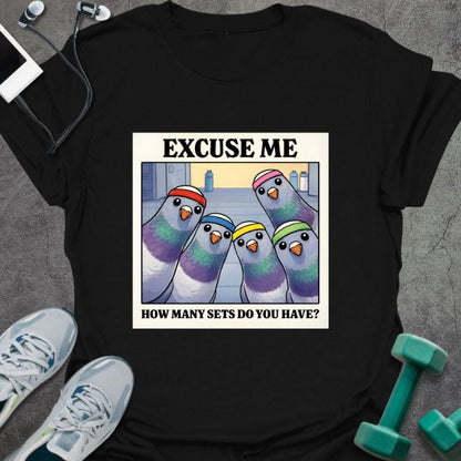 Black t-shirt printed with "Excuse Me How Many Sets Do You Have?" in multicolor, with colorful parrots in a row